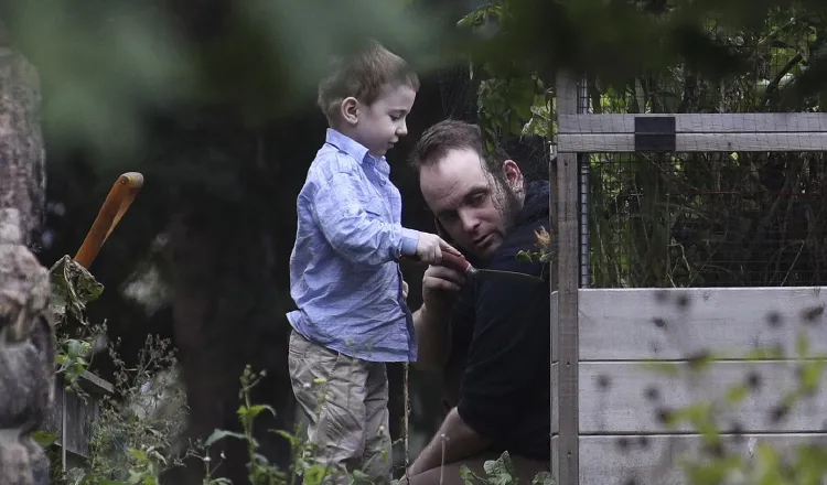 Joshua Boyle juega con uno de sus hijos en el jardín de la casa de sus padres. /Foto AP