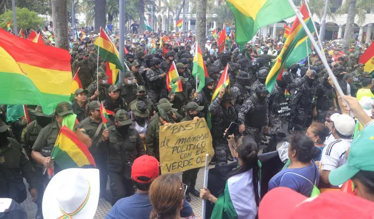 Un grupo de policías ondea la bandera tricolor de Bolivia mientras se repliega a una comisaría. FOTO/EFE
