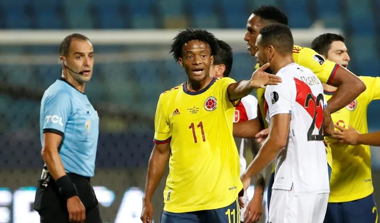 Juan Guillermo Cuadrado de Colombia discute una jugada durante el partido contra Perú. Foto:EFE