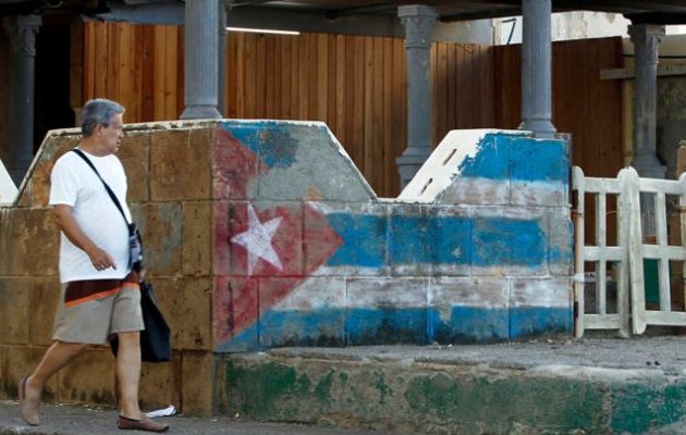 Un hombre camina junto a una pintura de la bandera cubana en La Habana (Cuba). Foto: EFE