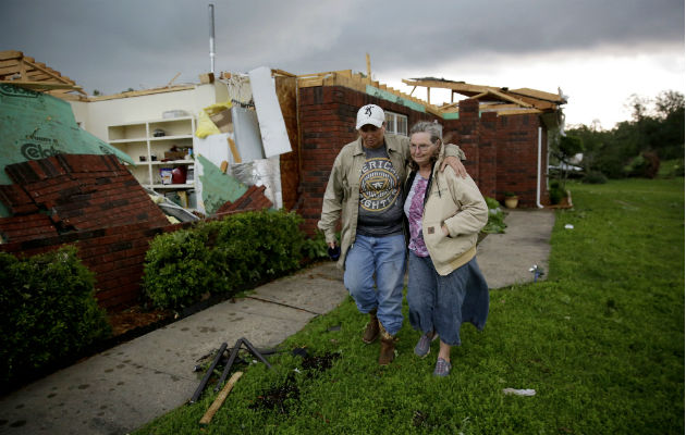 Una madre y su hijo tras su vivienda destruida por la tormenta. Foto: AP. 