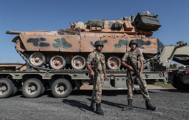 Jóvenes con la bandera turca al paso de blindados militares turcos en el noreste de Siria. Foto: EFE.