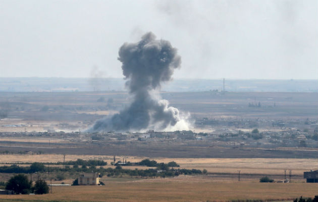 Jóvenes con la bandera turca al paso de blindados militares turcos en el noreste de Siria. Foto: EFE.