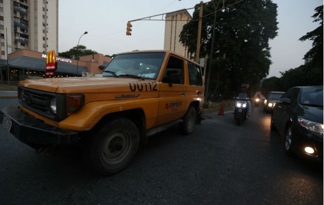 Vehículos transitan por una calle sin alumbrado público por la falta de fluido eléctrico en Caracas (Venezuela). Foto: EFE.