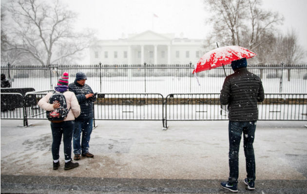 Varias personas contemplan el exterior nevado de la Casa Blanca en Washington D.C (Estados Unidos), durante la tormenta de nieve. Foto: EFE