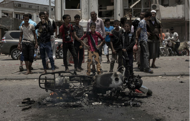Civiles observan una moto destruida en Aden. Foto: AP