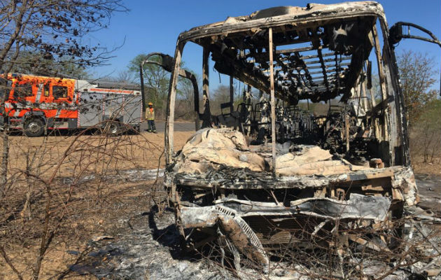 Un camión de bomberos se mantiene estacionado cerca del autobús quemado en Zimbabue. AP