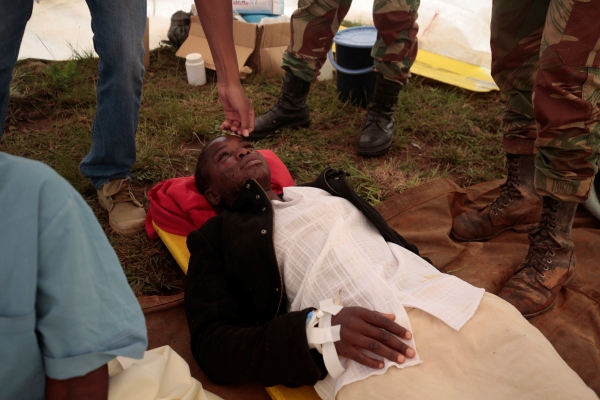 Miembros del Ejército Nacional de Zimbabwe observan a una mujer rescatada a las afueras de Chimanimani, a unos 500 km al este de la capital, Harare (Zimbabue). FOTO/EFE